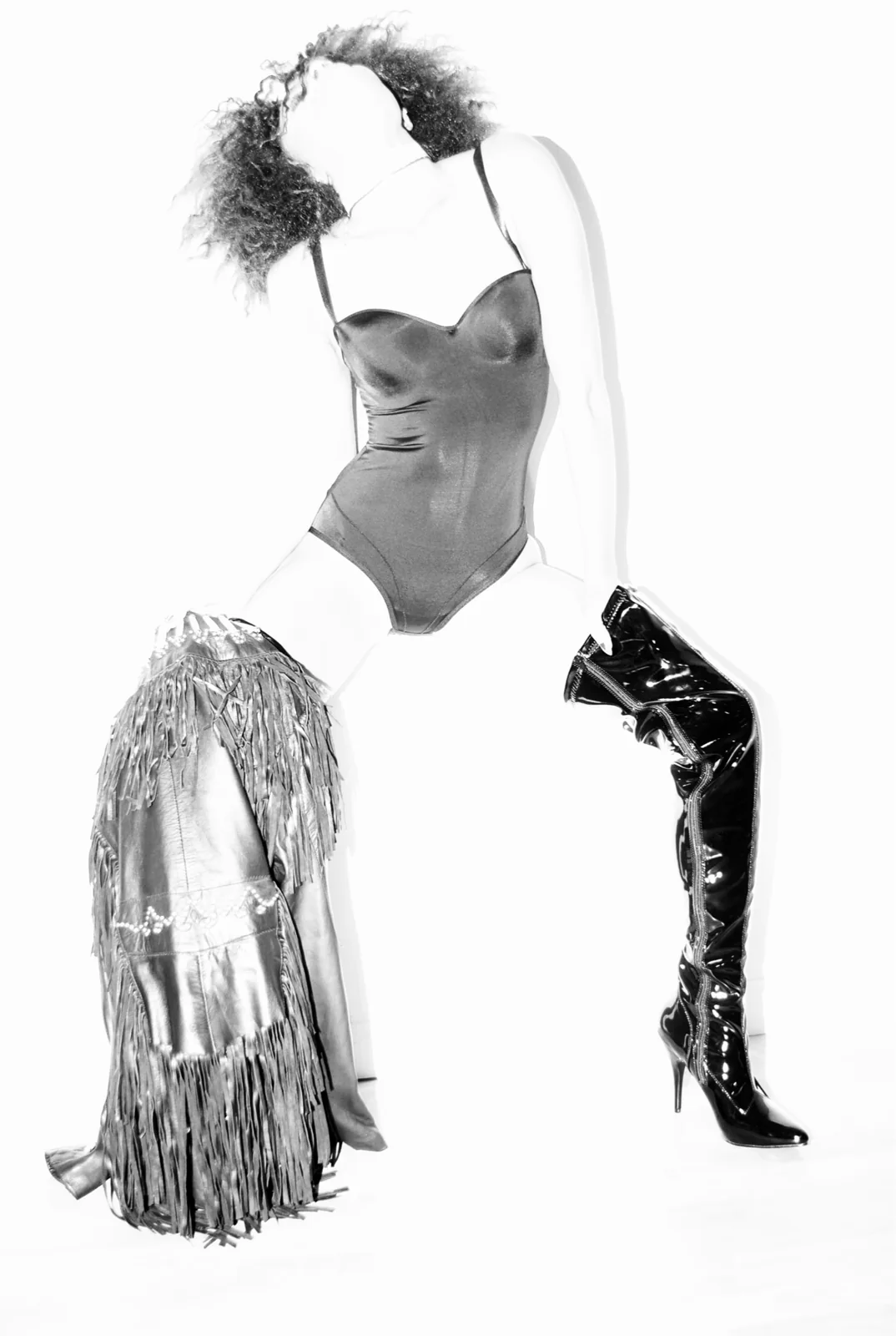 Black bodysuit with leather fringe chaps and patent over-the-knee boot
